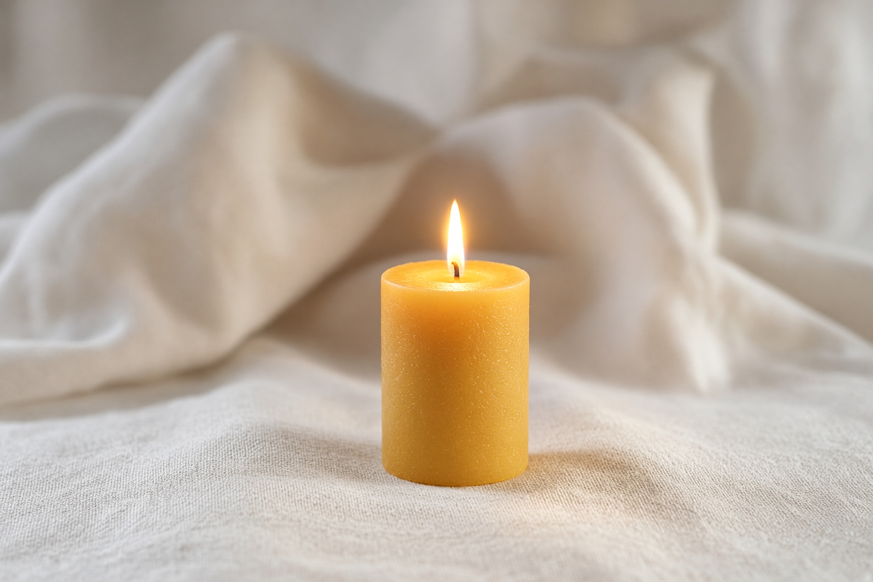A single candle on linen